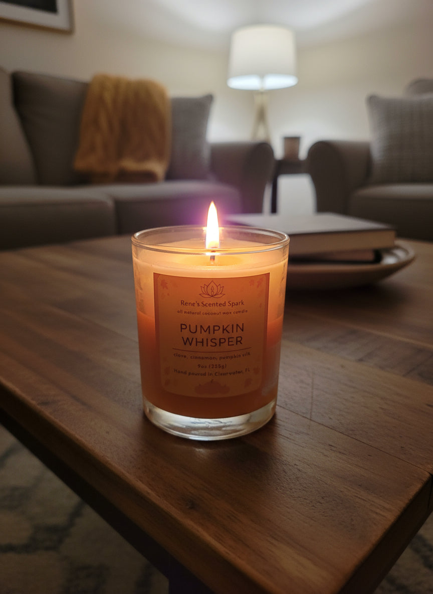 Candle labeled 'Pumpkin Whisper' by Rene's Scented Spark on a white block with a purple background