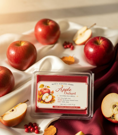 Apple Orchard 2.5 oz scented wax melts displayed on cream and burgundy satin with fresh red apples, sliced apples, red berries and autumn leaves