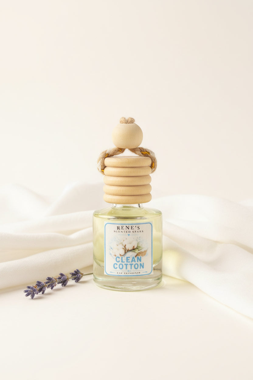 Clean Cotton hanging car air freshener by Rene’s Scented Spark displayed on soft flowing white linen with a delicate lavender sprig against a warm neutral background.