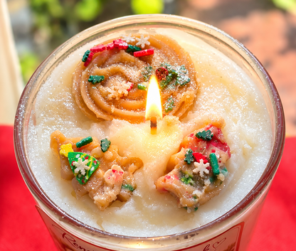 Close-up of lit Cookies for Santa candle top with hand-sculpted sugar cookie toppers, festive Christmas sprinkles and snowflakes