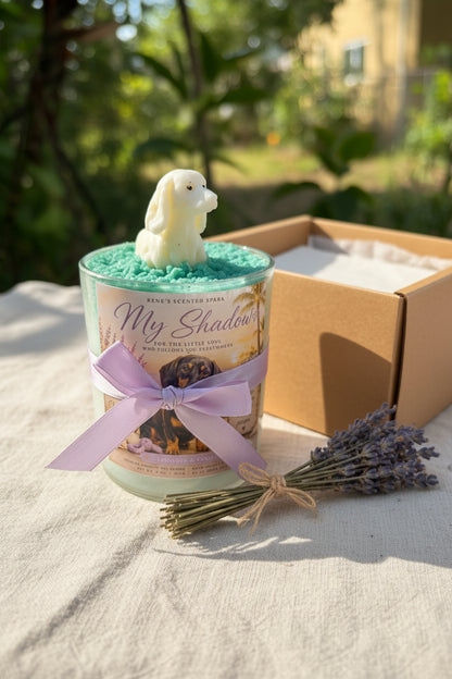 Candle with a dog figurine and lavender bundle on a sandy surface with greenery in the background