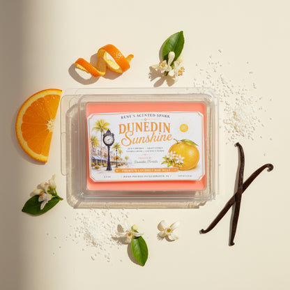 Dunedin Sunshine orange citrus wax melts by Rene’s Scented Spark surrounded by fresh orange, vanilla beans, orange blossoms, and coconut-inspired fragrance notes.