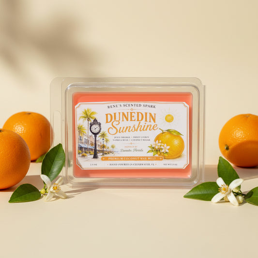 Dunedin Sunshine orange citrus wax melts by Rene’s Scented Spark, displayed with fresh oranges and orange blossoms, inspired by Dunedin, Florida.