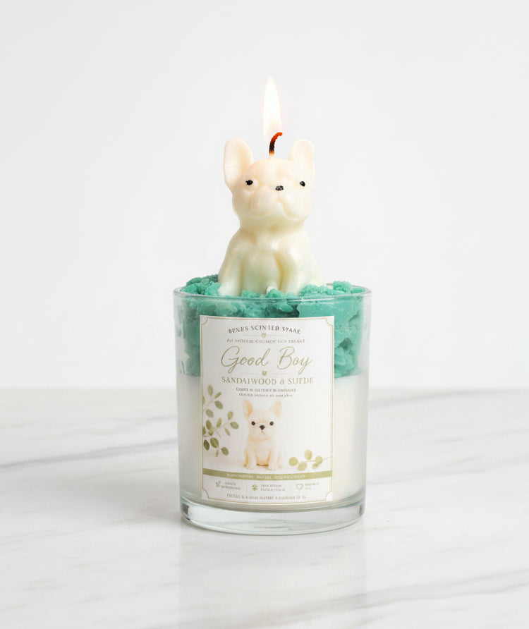 Good Boy French Bulldog candle in glass jar with teal green whipped wax and cream dog wax topper on white marble surface