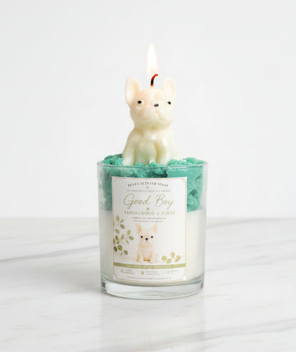 Good Boy French Bulldog candle in glass jar with teal green whipped wax and cream dog wax topper on white marble surface