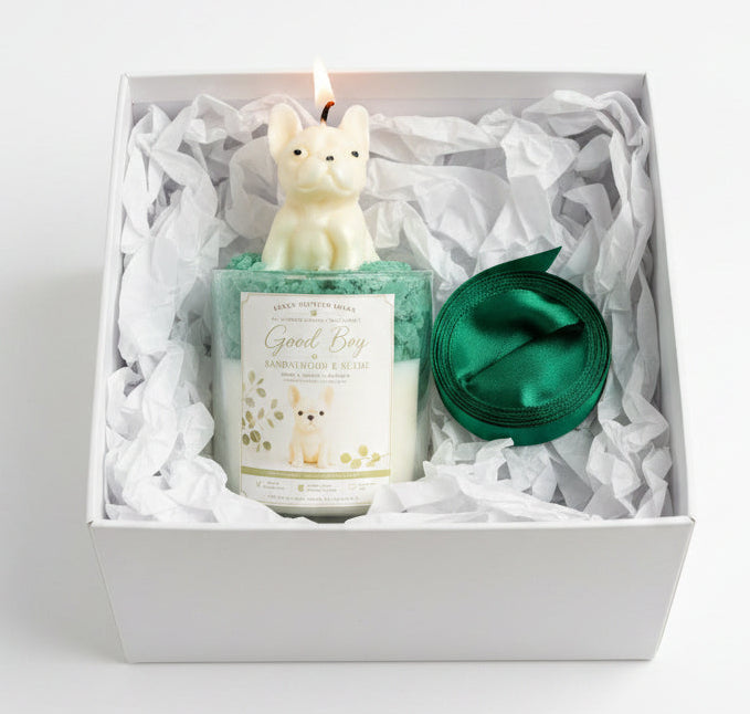 Good Boy candle with cream French Bulldog topper in open white gift box with green ornament on white background