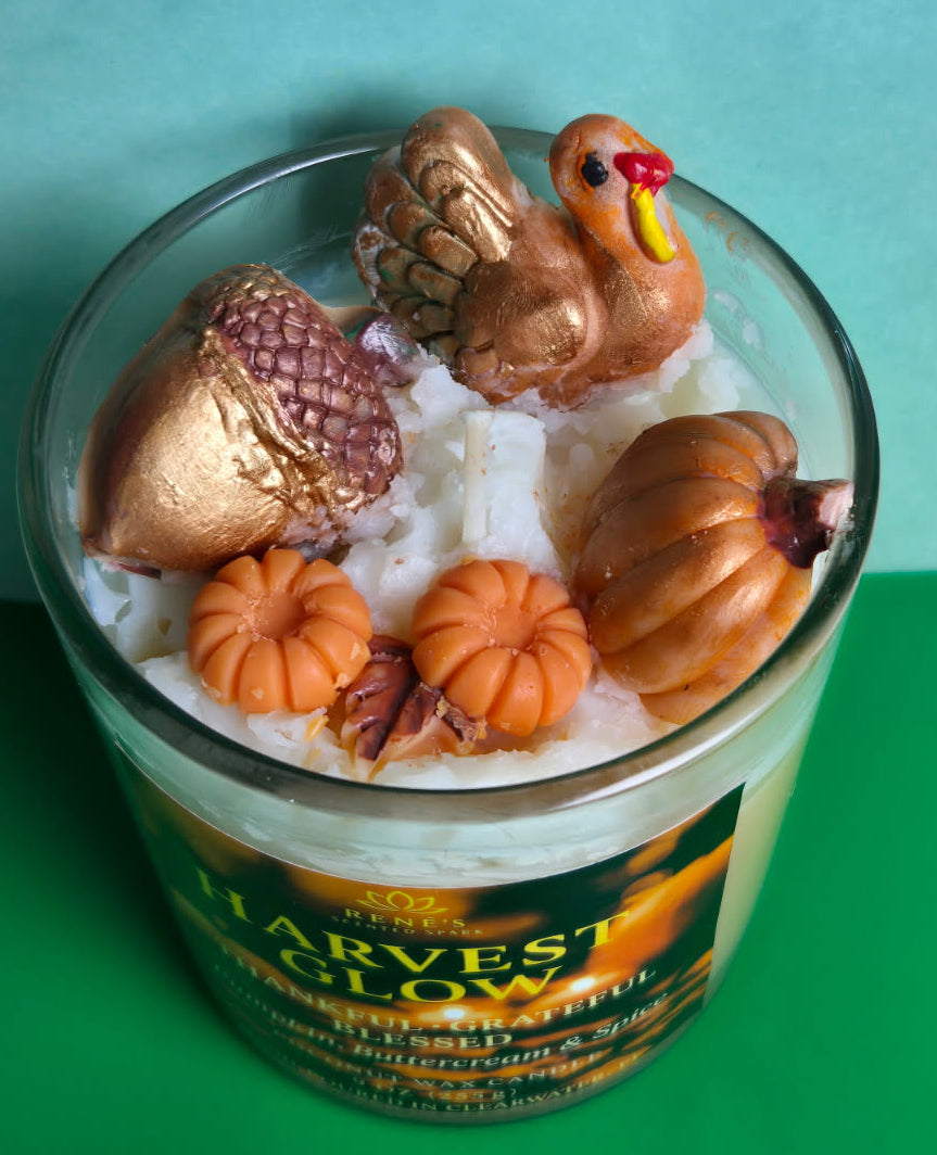Harvest-themed candle with decorative elements on a green background