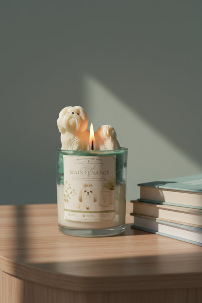 Candle with a label on a wooden surface with a stack of books in a brightly lit room