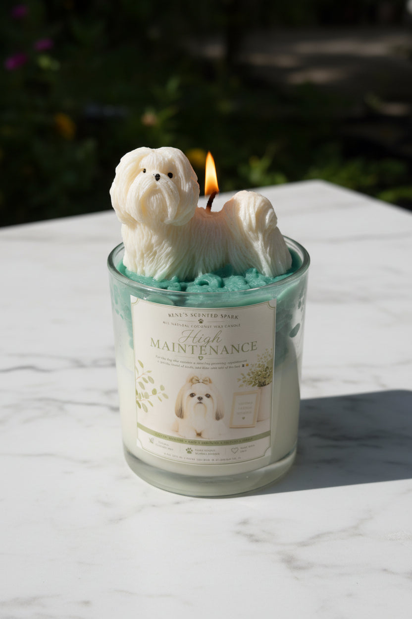 Two High Maintenance Shih Tzu candles with teal green whipped wax and white dog toppers on outdoor marble surface