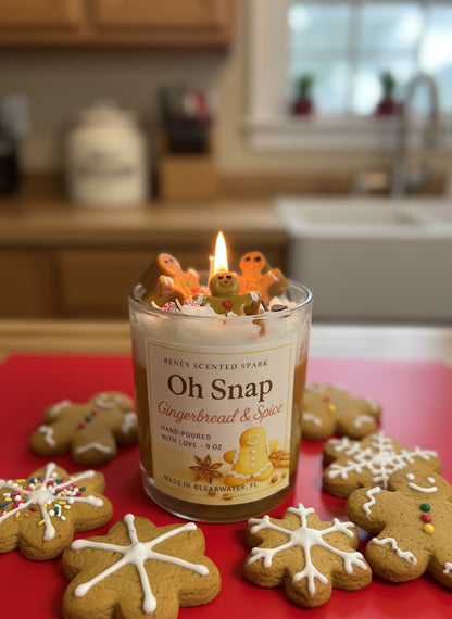 Candle labeled 'Oh Snap Gingerbread & Spice' with gingerbread cookies on a kitchen counter.