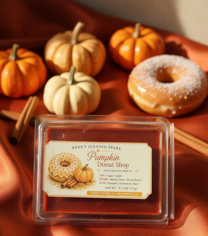 Pumpkin Donut Shop 2.5 oz scented wax melts displayed on burnt orange satin with fall pumpkins, cinnamon sticks and a glazed donut.