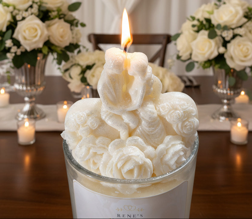 Close-up of bride and groom candle topper with sculpted roses and romantic wedding floral background