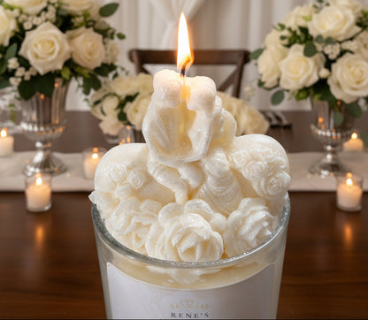 Close-up of bride and groom candle topper with sculpted roses and romantic wedding floral background