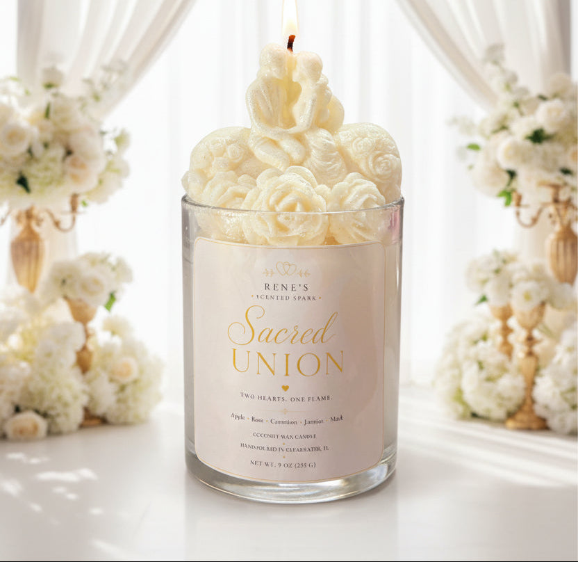 Bride and groom candle in glass jar with sculpted roses, glowing flame, white roses, and soft warm lights in background