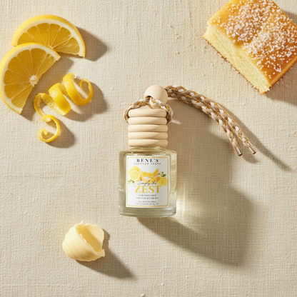 Simply the Zest lemon cake and vanilla car freshener by Rene’s Scented Spark styled with fresh lemon slices, lemon peel, butter, and cake. 🍋🍰