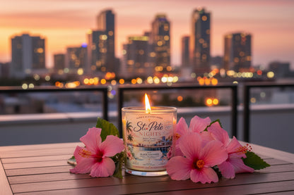 Candle in a glass container with a label on a blue sky background