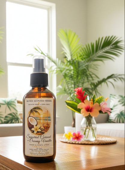 Sugared Coconut & Creamy Vanilla room spray by Rene’s Scented Spark in an amber spray bottle, displayed on a wooden table with tropical flowers, palm greenery, and warm natural sunlight.
