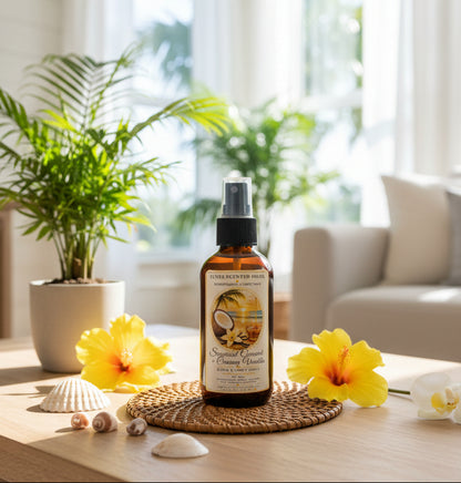 Sugared Coconut & Creamy Vanilla room spray by Rene’s Scented Spark in an amber spray bottle, styled with yellow tropical flowers, seashells, and lush green palms in a bright, sunlit room.