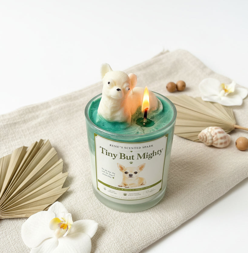Candle with a dog-shaped candle wick holder on a decorative surface with flowers and leaves.