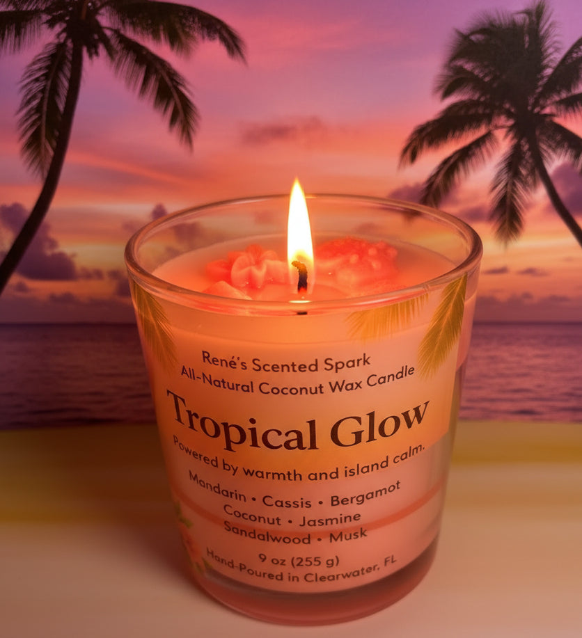 Lit Tropical Glow coconut wax candle featuring a palm-inspired label and glowing sunset backdrop.