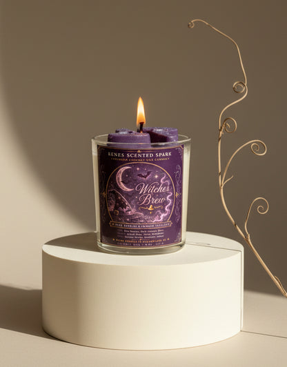 Witches Brew Halloween coconut wax candle burning on a cream pedestal in warm natural light with purple witch hat wax toppers and minimalist fall styling.