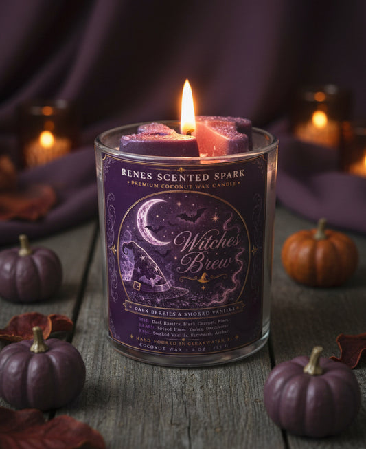 Witches Brew Halloween coconut wax candle with purple witch hat toppers, surrounded by mini pumpkins in a dark cozy fall setting.