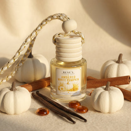 Ambered White Pumpkin car freshener styled with white pumpkins, cinnamon sticks, vanilla beans and amber accents in a warm autumn setting.