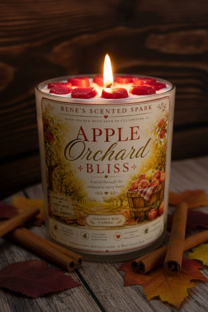 Candle labeled 'Apple Orchard Bliss' with cinnamon sticks and leaves on a wooden surface