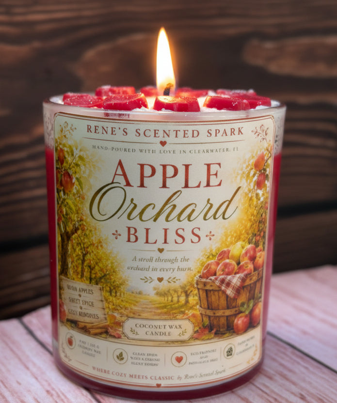 Lit Apple Orchard Bliss coconut wax candle by Rene's Scented Spark with a handcrafted apple wax topper, featuring orchard-inspired artwork in a clear glass jar on a rustic wooden surface.