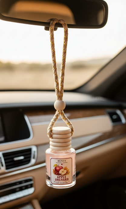 Apple Orchard car freshener by Renes Scented Spark in a hanging glass diffuser bottle, styled with a red apple and warm autumn decor.