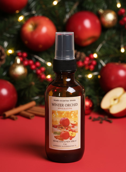 apple-themed home and linen spray bottle with christmas decorations and apples in the background with holiday baking spices