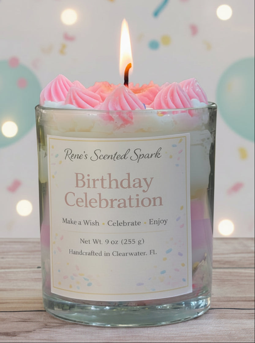 Candle in a glass jar labeled 'Birthday Celebration' with pink frosting on top, against a light background.