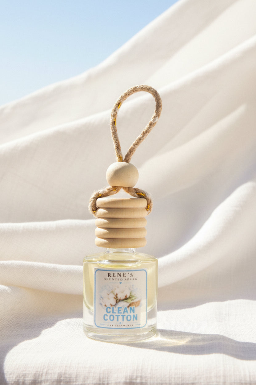 Clean Cotton hanging car air freshener by Rene’s Scented Spark displayed against flowing white linen in soft natural sunlight with a pale blue sky background.
