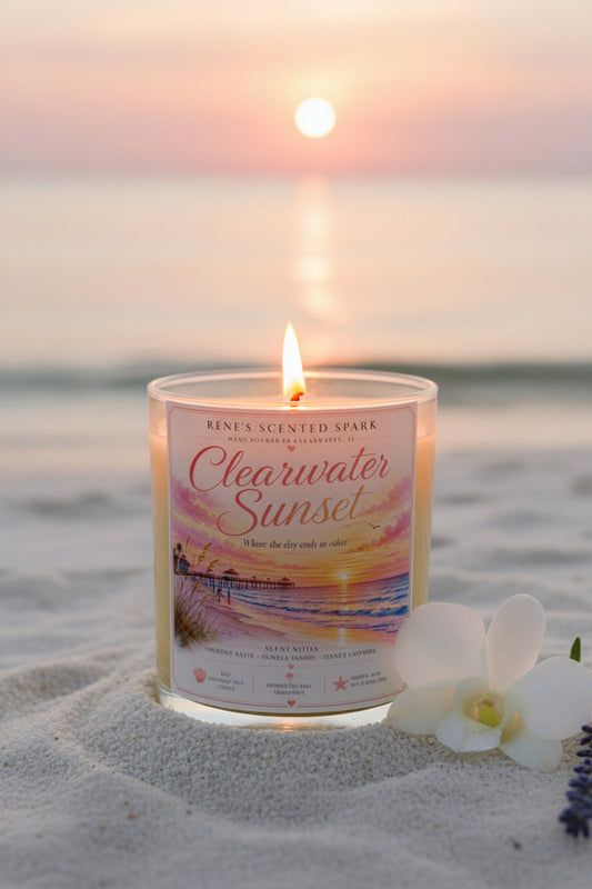 Candle labeled 'Clearwater Sunset' on a beach with a sunset in the background