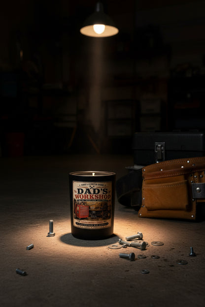 Dad's Workshop masculine candle dramatically lit by a single spotlight in a dark garage atmosphere
