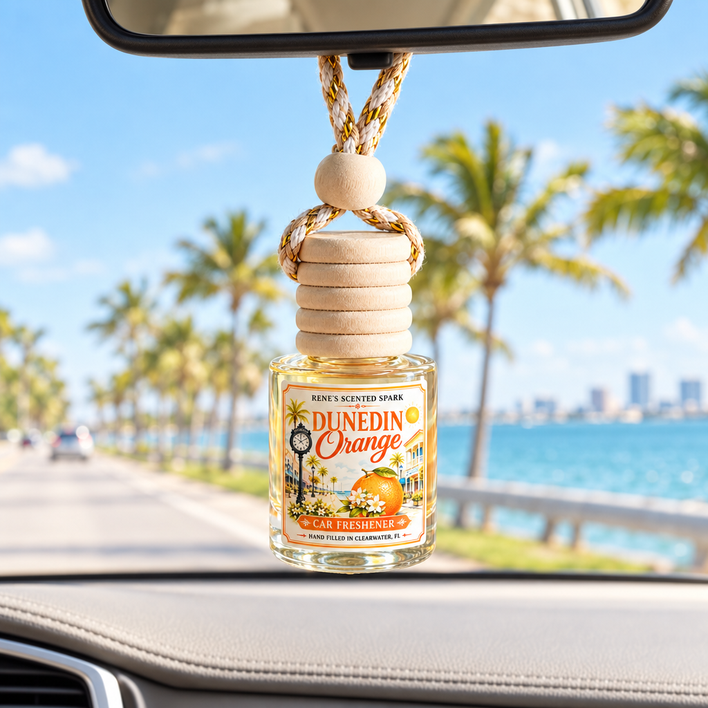 Dunedin Orange car freshener hanging in a car on a sunny Florida causeway with palm trees and turquoise water