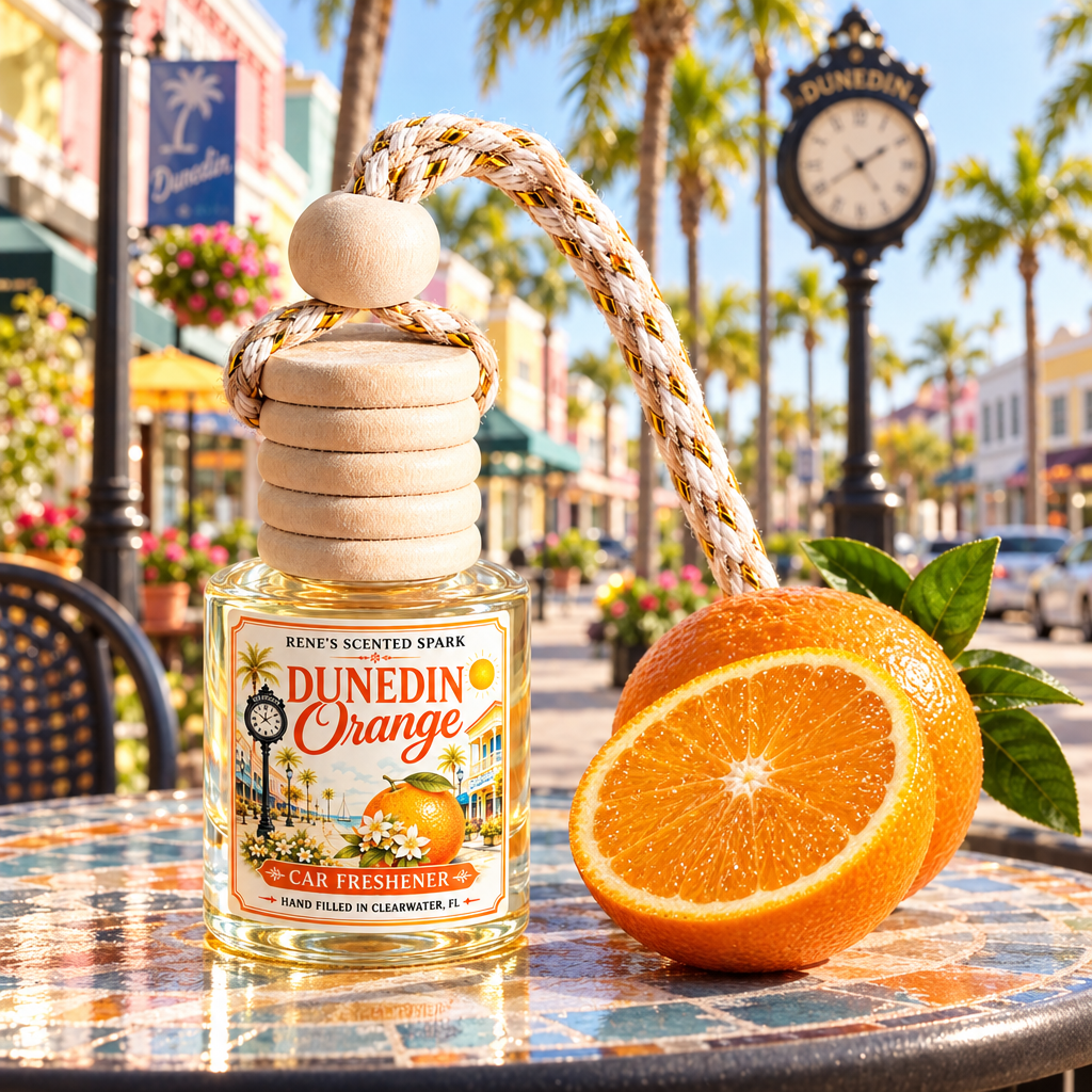 Dunedin Orange car air freshener on a café table on a sunny Florida main street with palm trees and a vintage clock