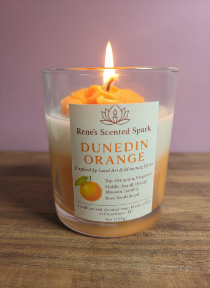 Hand-poured Dunedin Orange candle by Rene’s Scented Spark, featuring a vibrant orange rose top and locally inspired label, made in Clearwater, Florida.