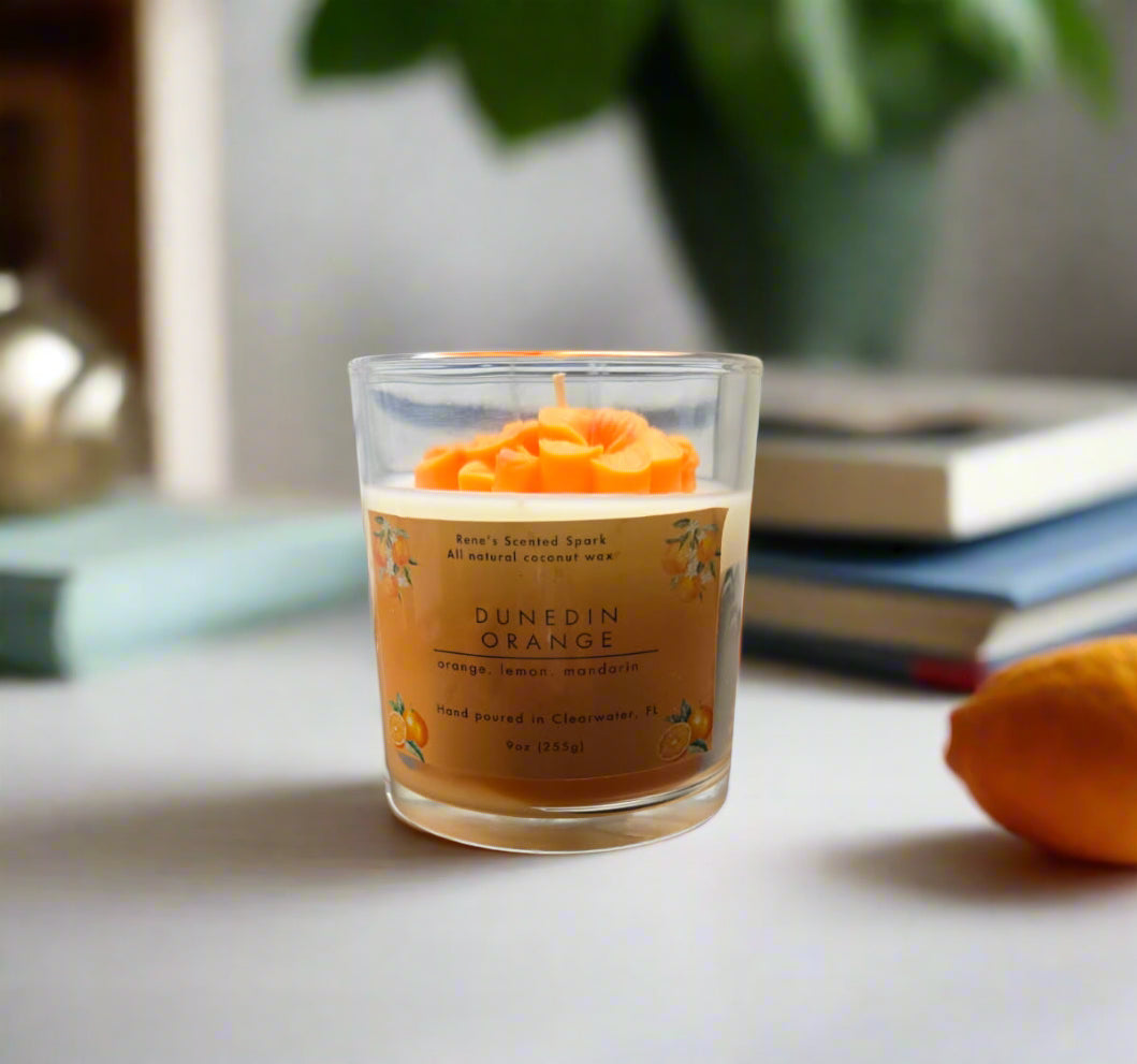Handcrafted Dunedin Orange candle in gift-ready packaging, citrus blossom design with orange and white wax, inspired by Dunedin art