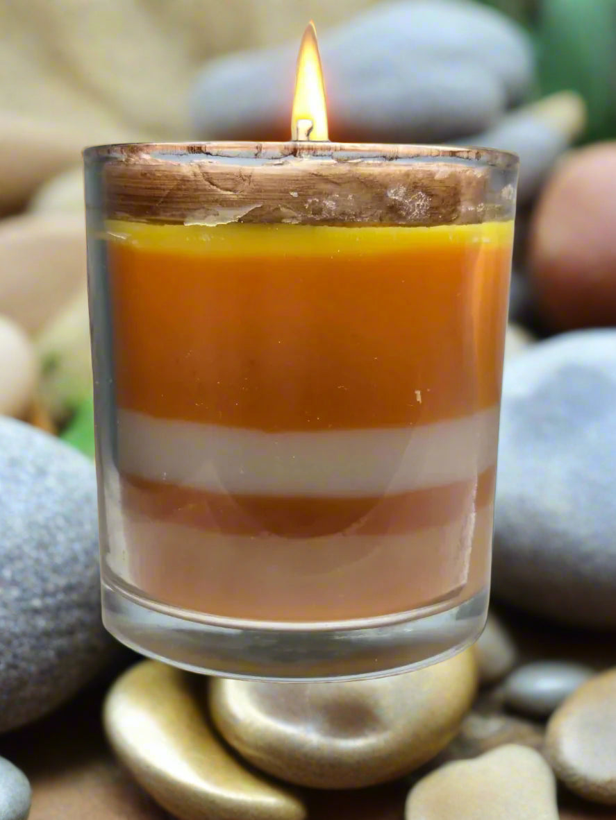 Spiritual candle collection displayed on a wooden table with Ember of Strength candle topped with phoenix and dragon, and Tranquil Spirit candle beside a Buddha figure. Surrounded by crystals, stones, and greenery — symbolic gift candles for meditation, healing, and renewal