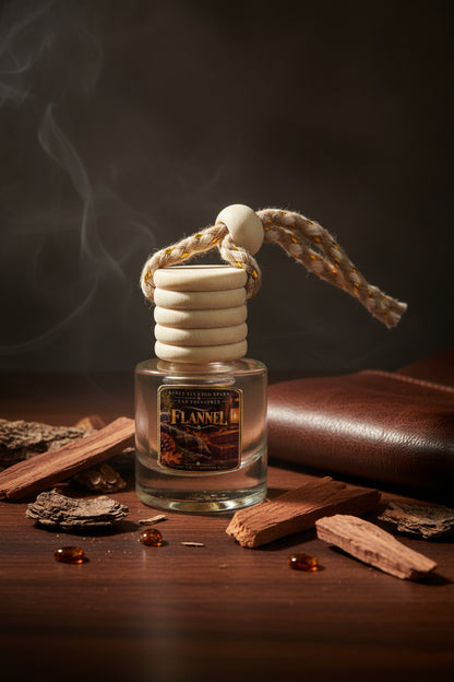 Flannel car freshener by Rene's Scented Spark styled with brown leather, rustic wood pieces, amber accents, and a soft smoky background.