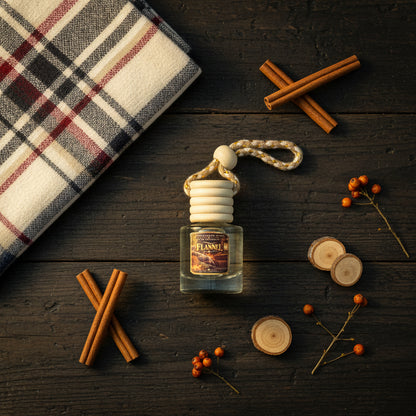 Flannel car freshener by Rene's Scented Spark styled on dark rustic wood with plaid flannel fabric, cinnamon sticks, wood accents, and autumn berries.