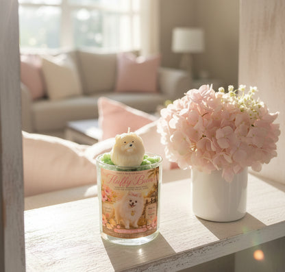 Candle with a dog design and pink flowers on a table in a living room.
