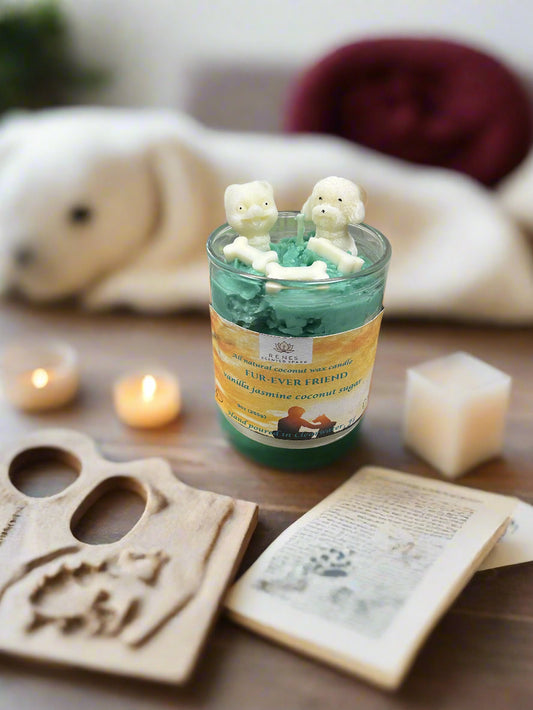 Candle with dog-shaped wick trimmer on a wooden surface with candles and a book.