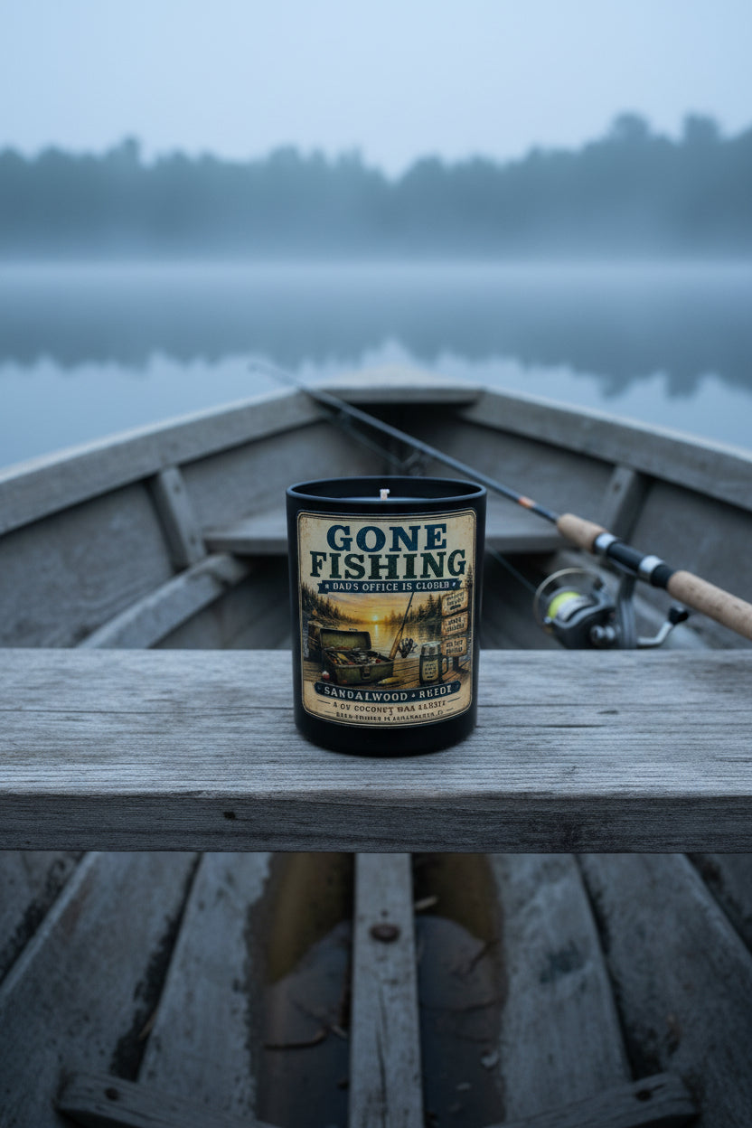 Gone Fishing candle sitting on a wooden boat bench on a misty calm lake at early morning