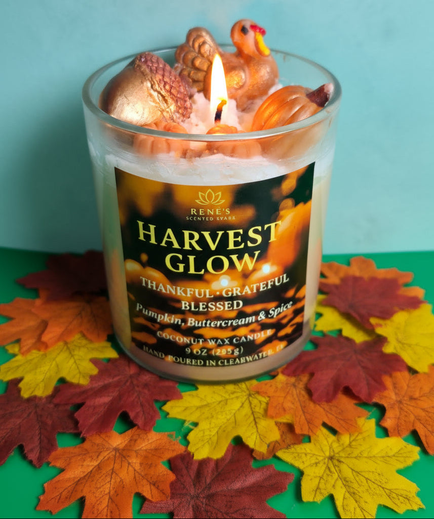 Harvest-themed candle with decorative elements on a colorful leaf background