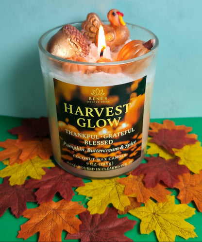 Harvest-themed candle with decorative elements on a colorful leaf background