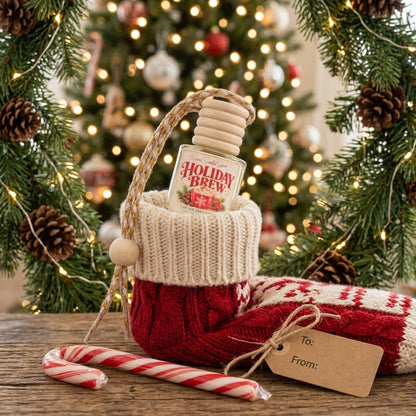 Holiday Brew Christmas car freshener in a knit stocking with a candy cane and gift tag by a lit Christmas tree