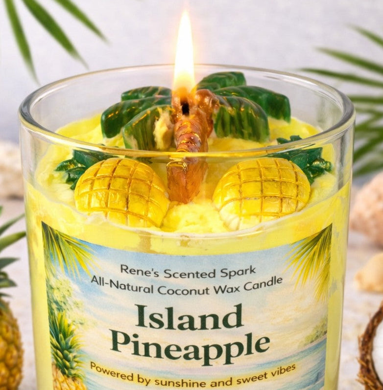Candle labeled 'Island Pineapple' with pineapple and leaf decorations, surrounded by greenery.