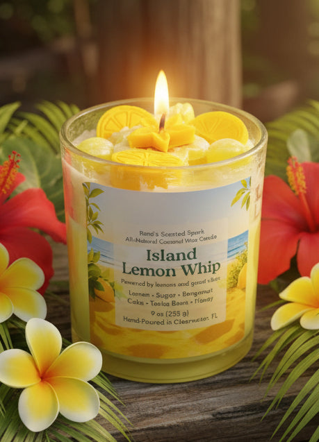 Candle labeled 'Island Lemon Whip' with lemons on top, surrounded by tropical flowers.
